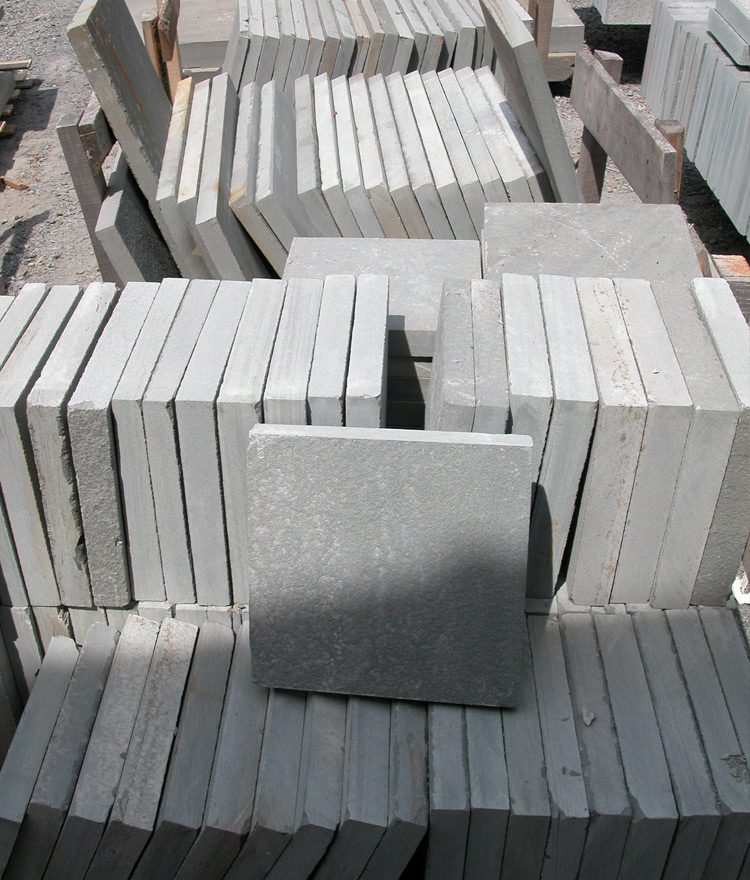 Pattern-cut thermal bluestone in the racks — dimensional stock from 12x12 to 24x36.
